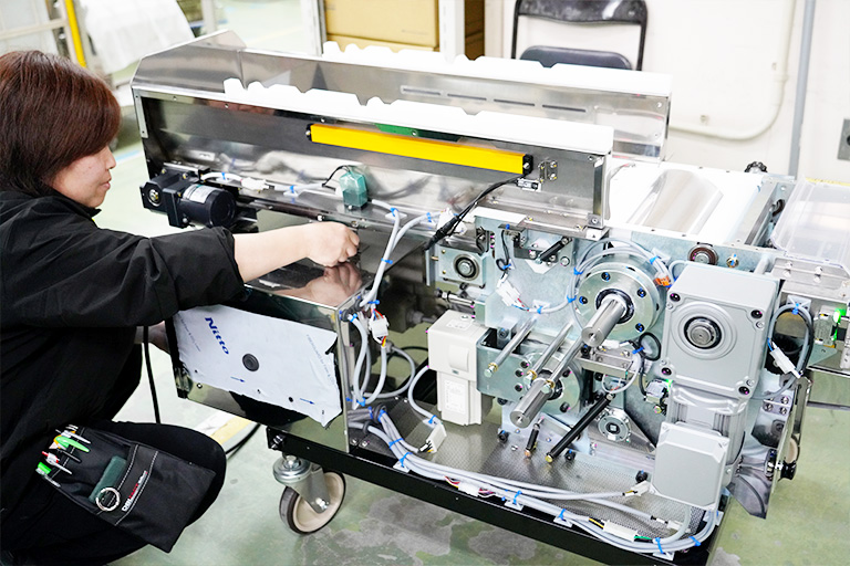 Technician servicing a Yamato noodle machine